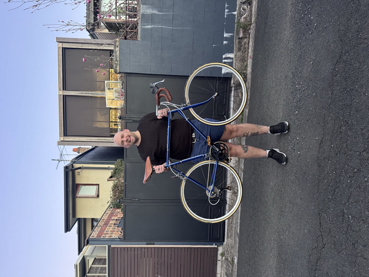 Alex holding a restored vintage road bike in a Sydney laneway